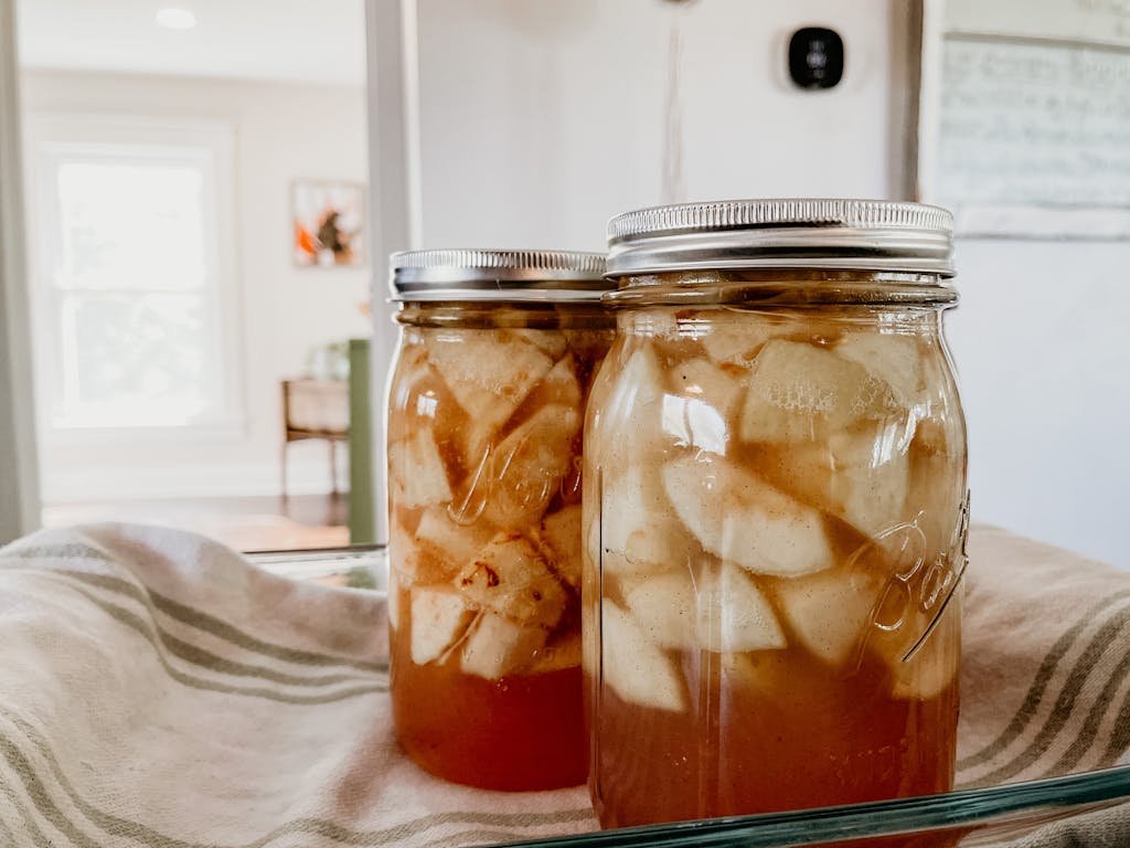 Close-up of homemade apple preserves in glass jars, perfect for cozy home kitchens.