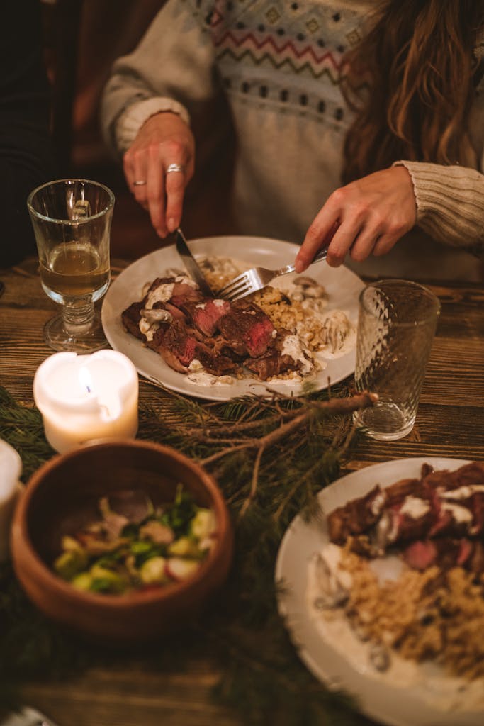 Warm and inviting winter dinner setting with beef, candles, and cozy decor.